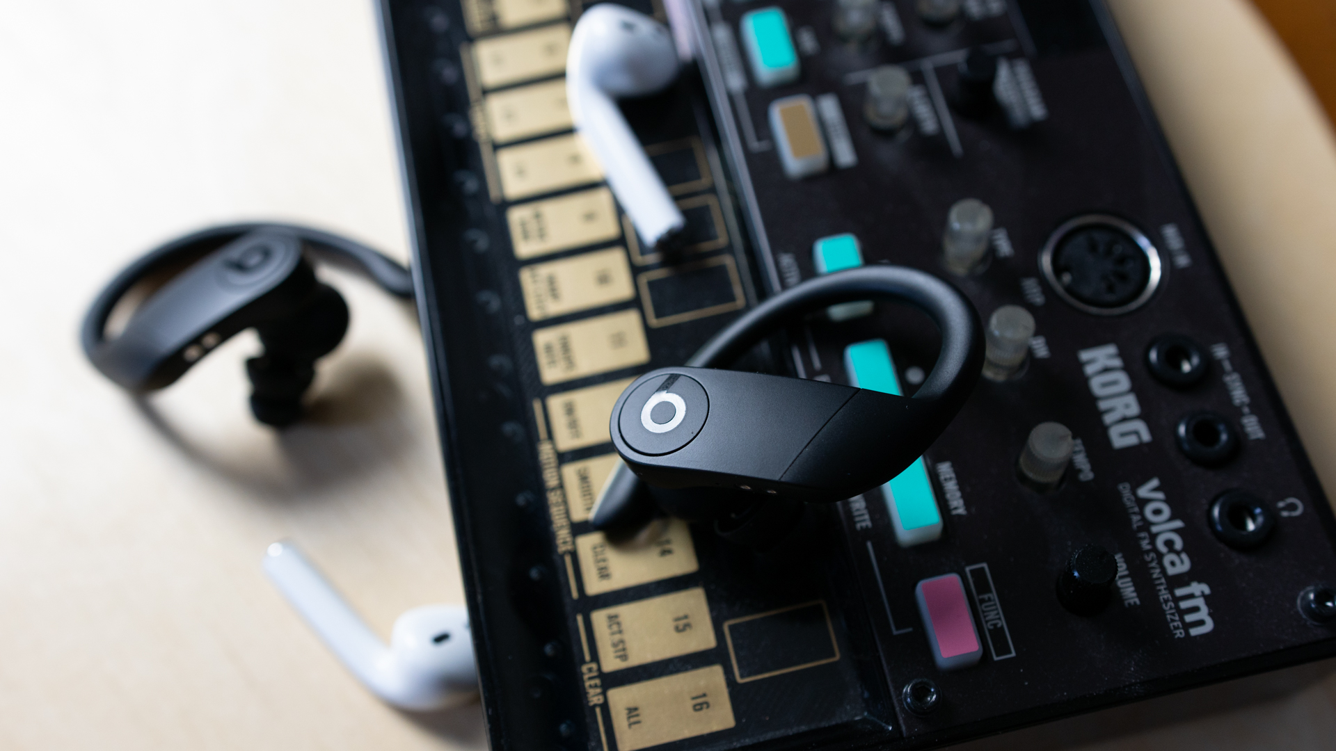 Apple Airpods Vs Powerbeats Pro-6 Close-up shot of the Apple Airpods and the Powerbeats Pro on a synth.