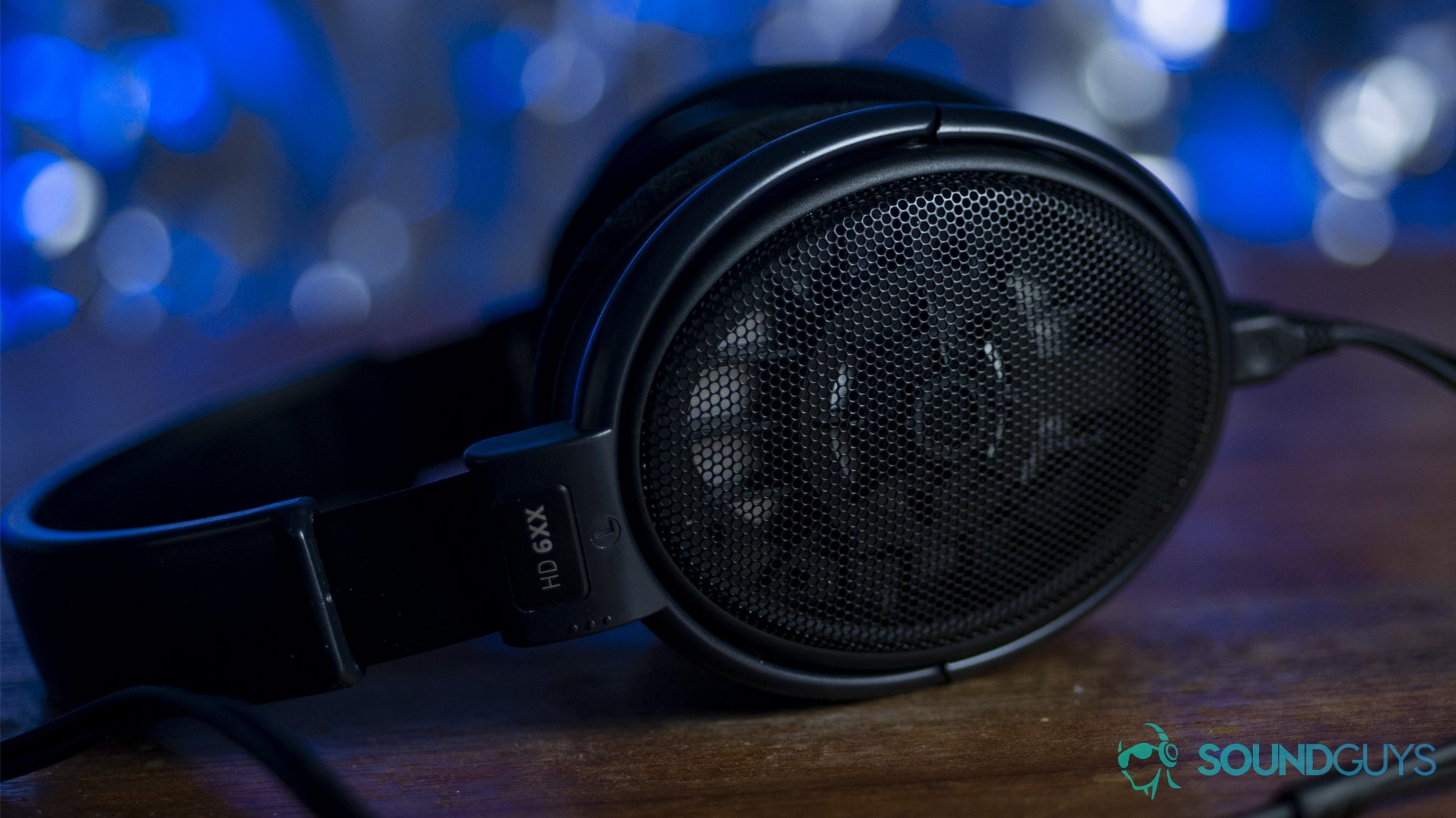 drop-x-sennheiser-hd-6xx-hero The Sennheiser HD 6XX headphones in black against a blurred out blue, shimmering background.