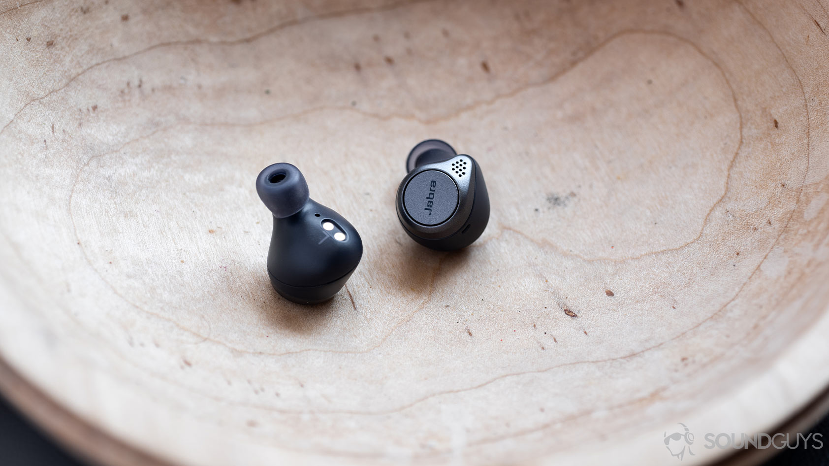 Jabra Elite Active 75t-true wireless workout earbuds A picture of the Jabra Elite Active 75t true wireless workout earbuds in navy inside a wooden bowl.