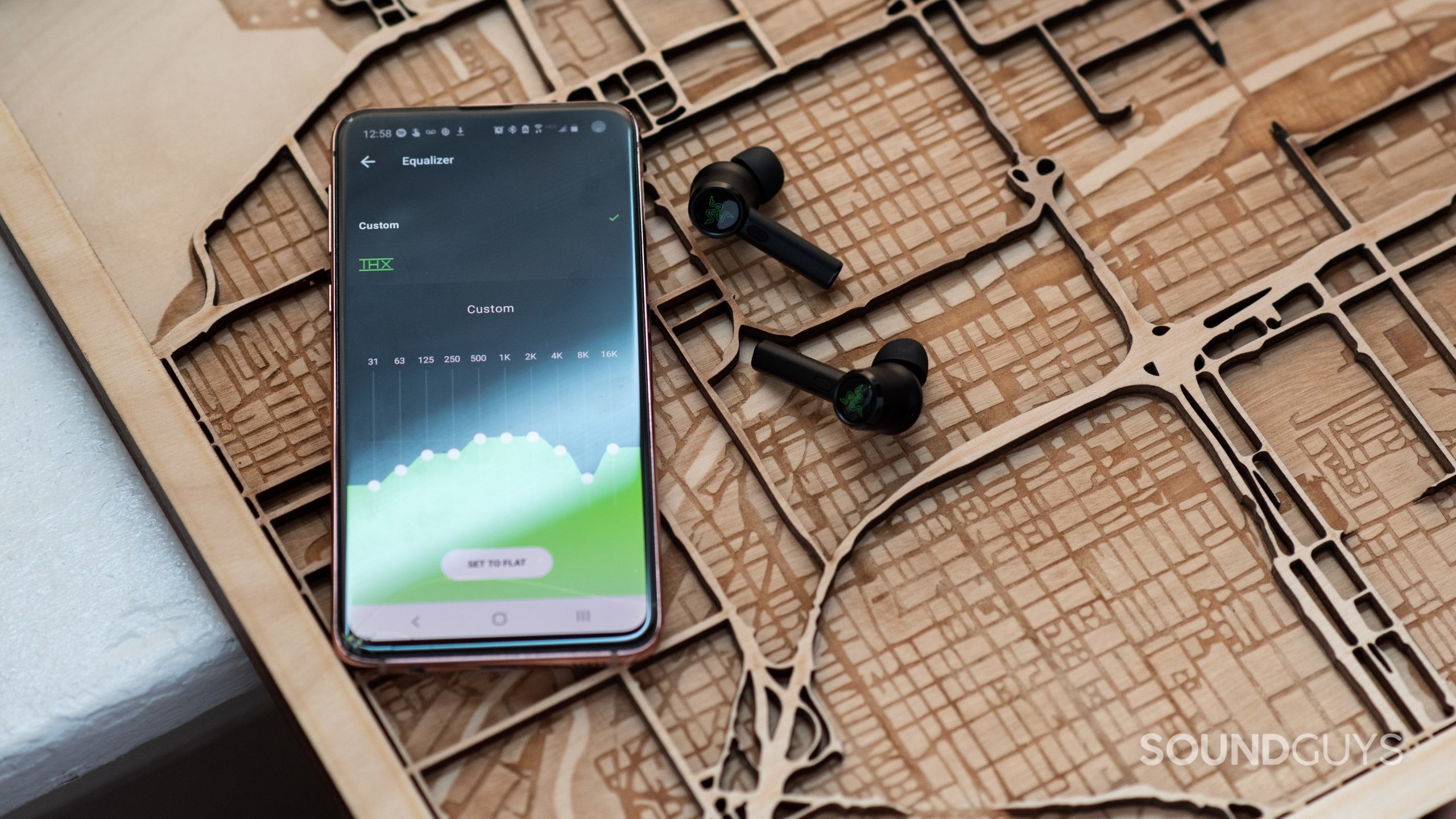 Razer Hammerhead True Wireless Pro-7 The Razer Hammerhead True Wireless Android app open on a Samsung Galaxy S10e smartphone next to the Razer Hammerhead True Wireless Pro earbuds.