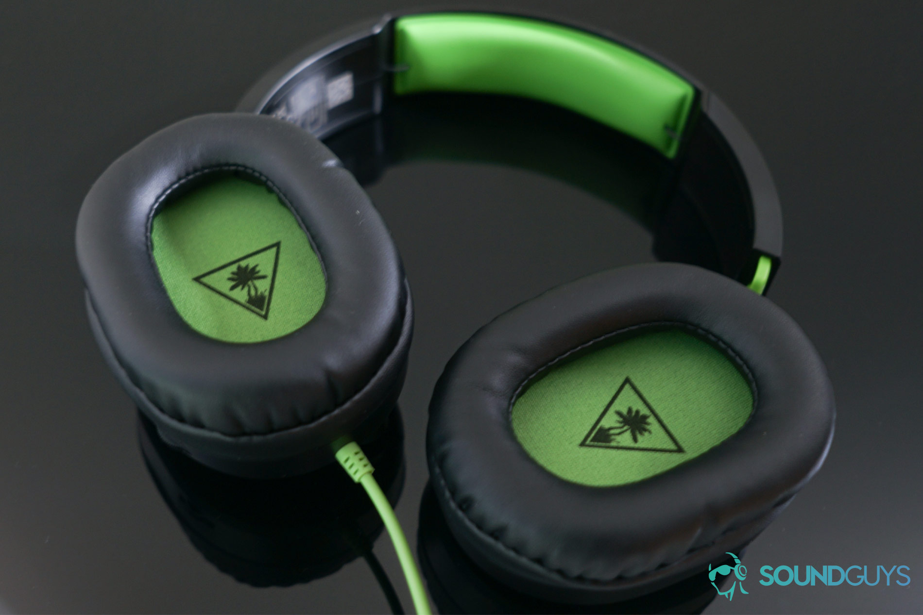 Turtle Beach Recon 70 gaming headset ear cups The Turtle Beach Recon 70 gaming headset's ear cups which are lined with a green material that matches the headband.