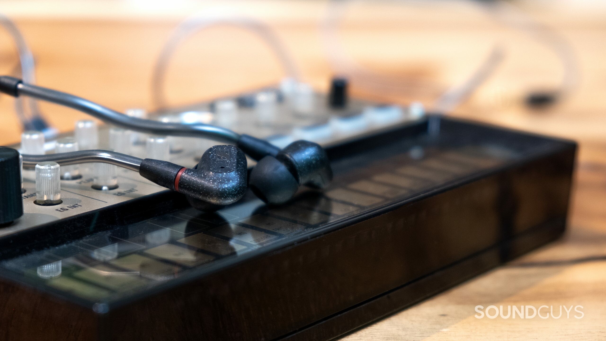 sennheiser ie 300 synth The Sennheiser IE 300 shot with a shallow depth of field, rest on a synthesizer.
