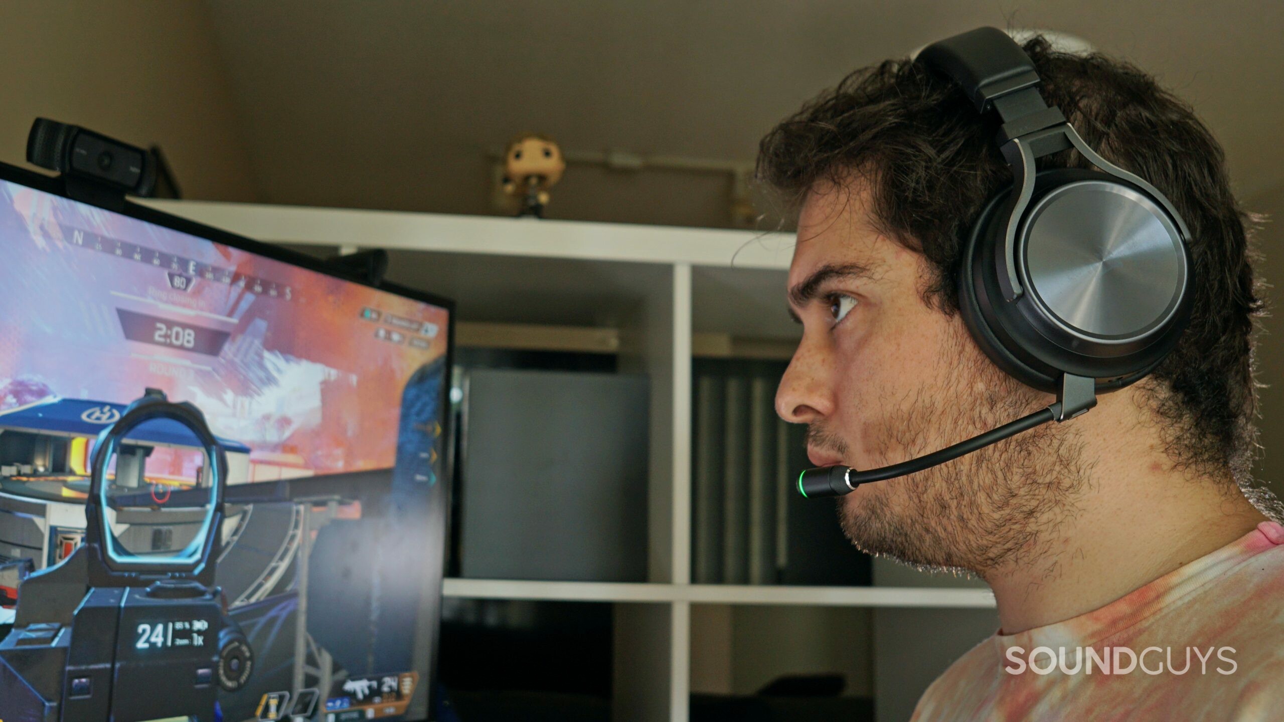 Corsair-Virtuoso-RGB-Wireless-XT-headshot A man sits a computer playing Apex Legends wearing the Corsair Virtuoso RGB Wireless XT.