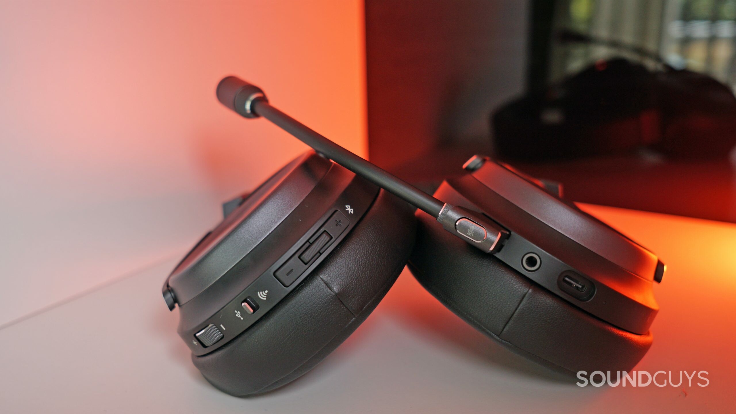 Corsair-Virtuoso-RGB-Wireless-XT-shelf-shot The Corsair Virtuoso lays on a white shelf with a red light in the background.