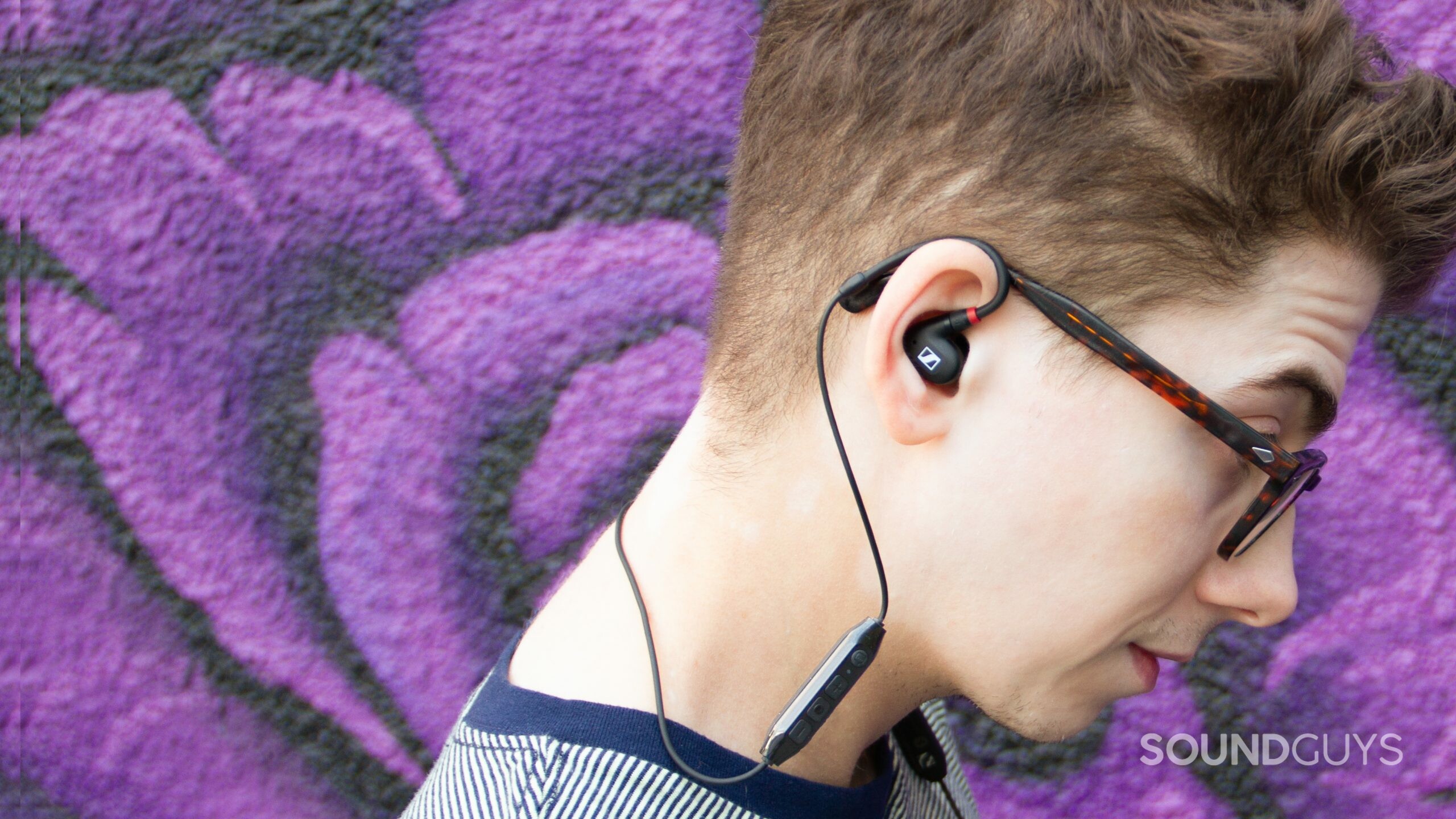 Image shows a man from the side with a purple background wearing the Sennheiser IE 100 PRO Wireless.