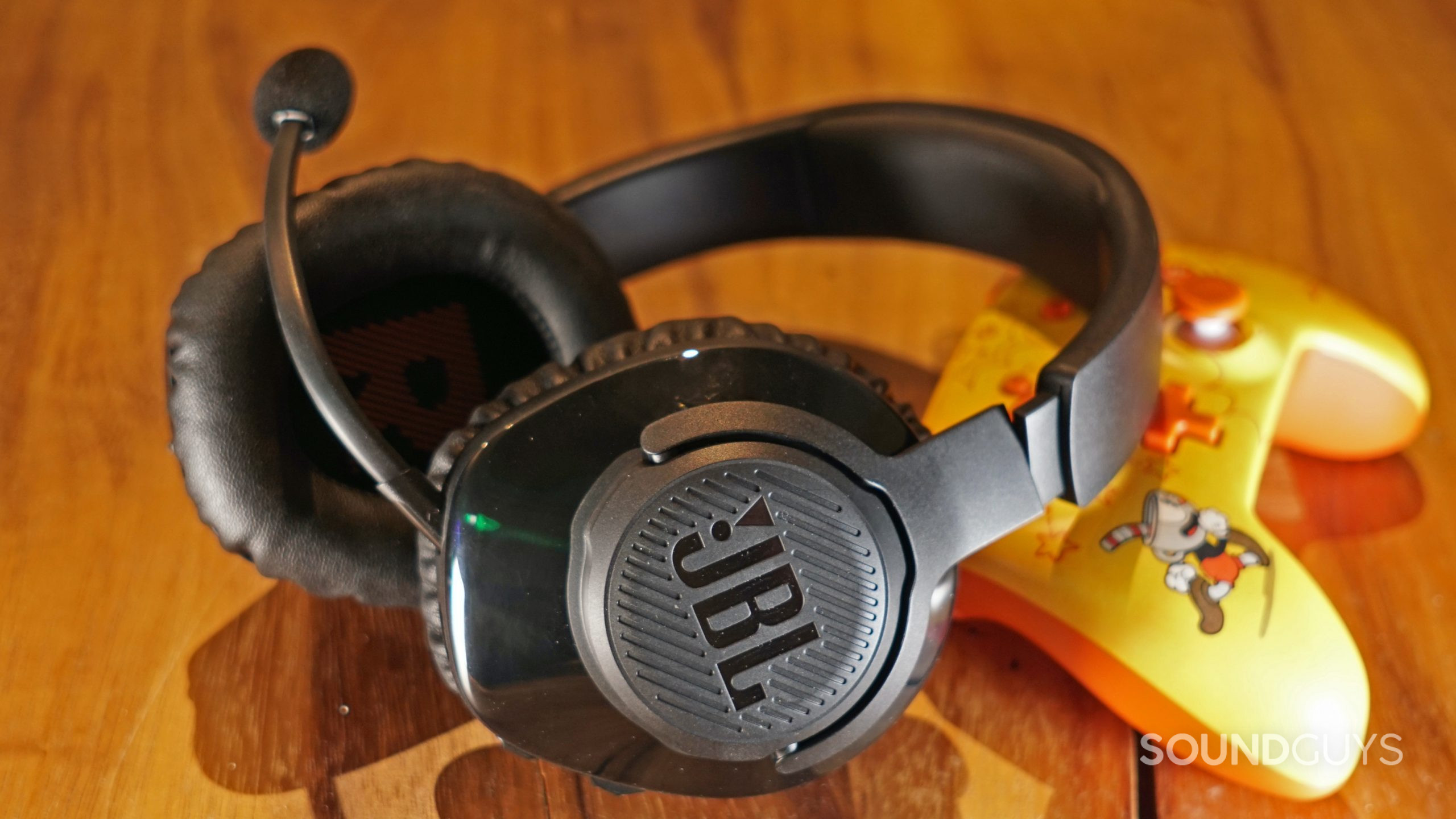 JBL-Quantum-350-Switch-controller-shot JBL Quantum 350 Wireless headset on a table beside a Cuphead branded controller for the Nintendo Switch.