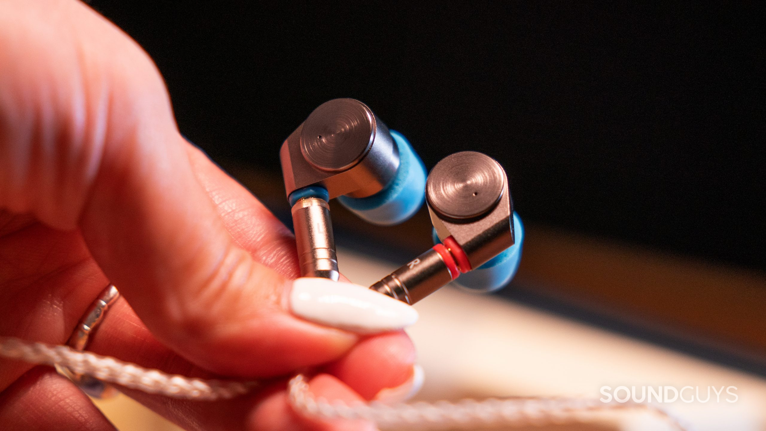 TIN HiFi T2-center A woman's hand with long nails holds the Linsoul TIN Audio T2 buds at a close up.