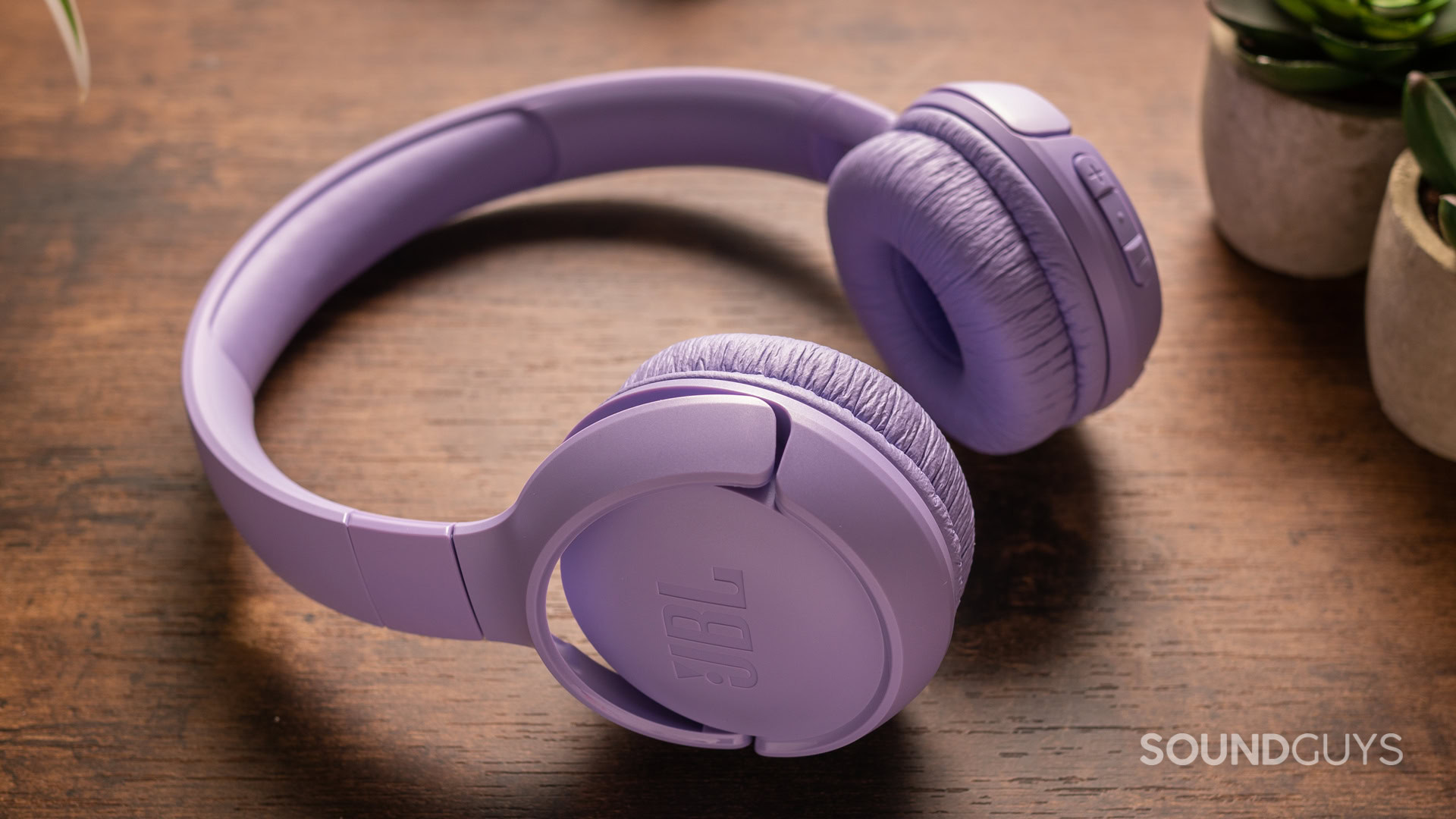 jbl-tune-520bt-off-angle A photo of the purple JBL Tune 520BT atop a wooden desk.